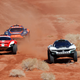 A photo of three Extreme E cars racing on sand.